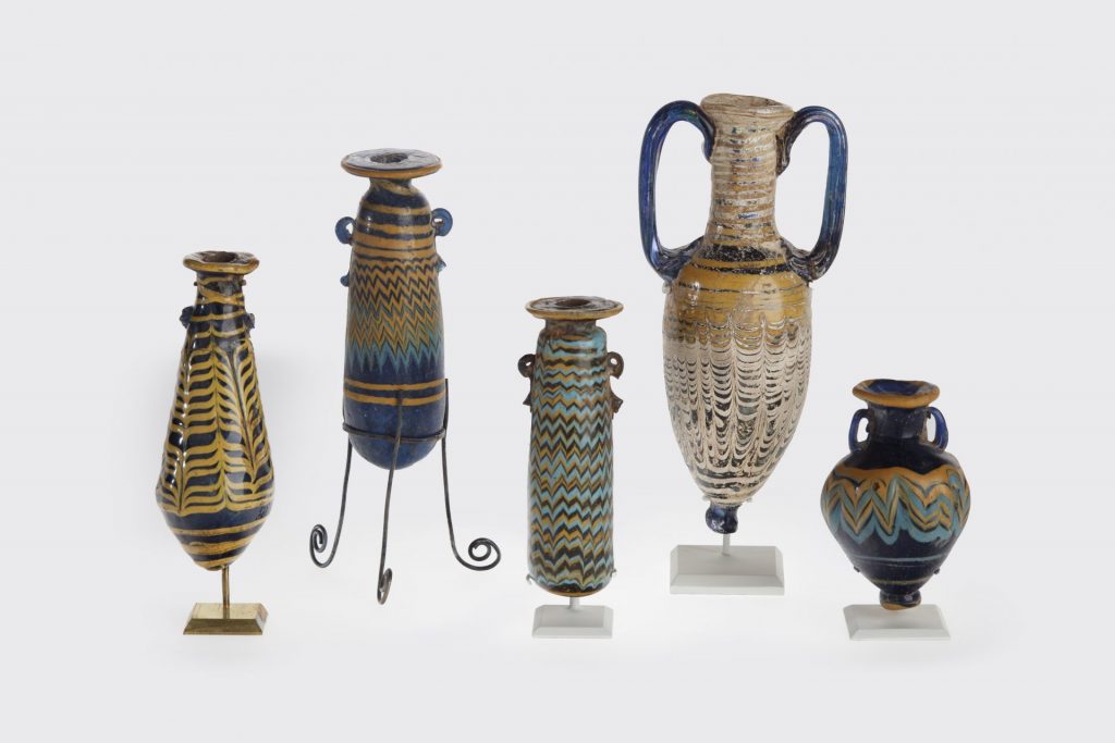 Eastern Mediterranean, Group of Five Unguent Bottles, 600–100 BCE. Glass, core-formed with trailed decoration; largest 5 7/8 × 1 1/8 in. New Orleans Museum of Art, Gift of Melvin P. Billups in memory of his wife, Clarice Marston Billups 56.92, 56.153, 64.82, 56.155, 56.154