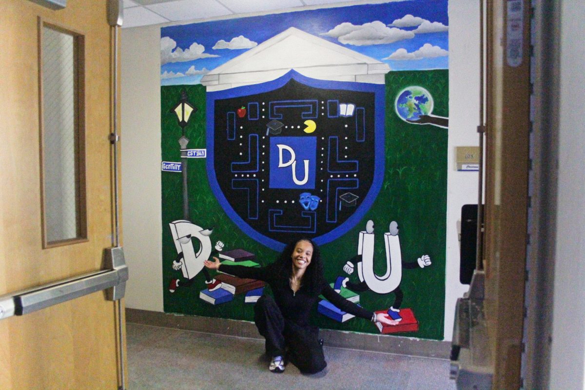 Ronnesha Ewing poses by her mural in the Cook Fine Arts Building.